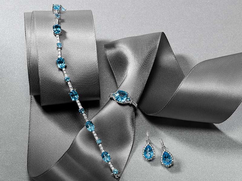Blue topaz line bracelet and drop earrings on grey satin ribbon