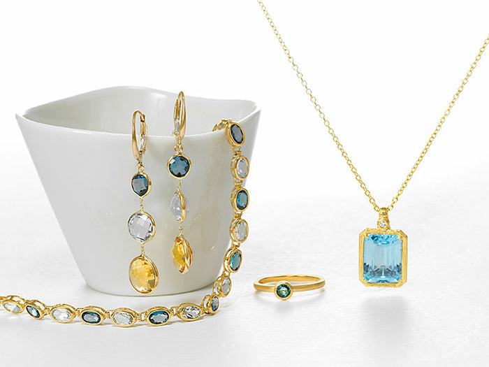 Blue topaz and multi-gemstone earrings, bracelet, ring and pendant in yellow gold