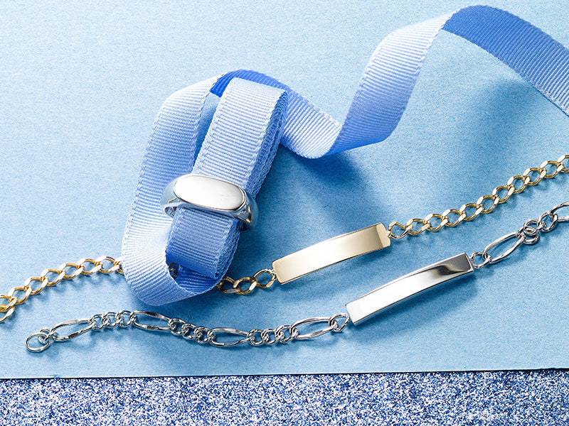 ID bracelets and a signet ring on blue ribbon